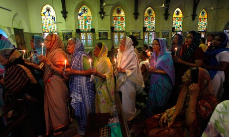 Catholic women hold candles and pictures of Pope Francis at a church in Kolkata